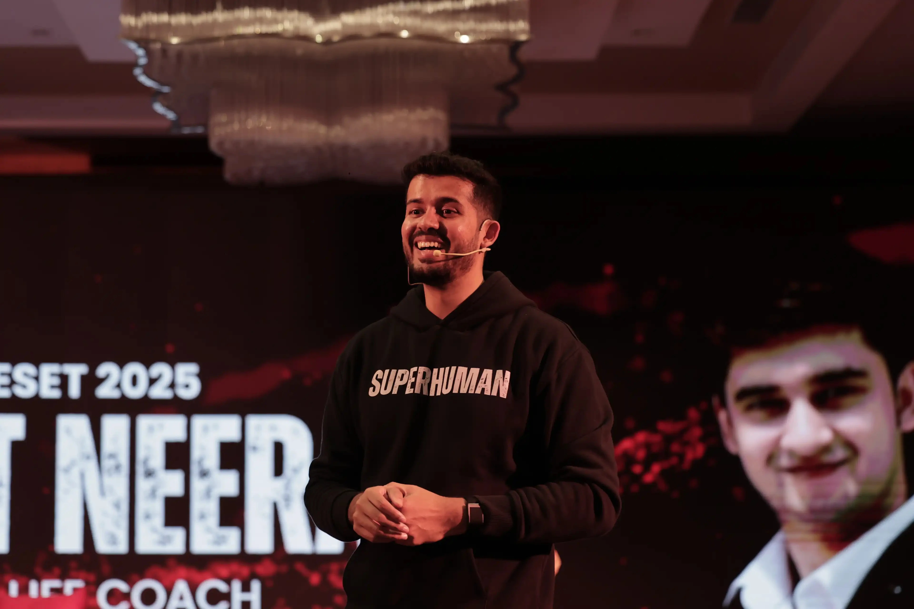 Swastik Nandakumar speaking on stage at a live event
