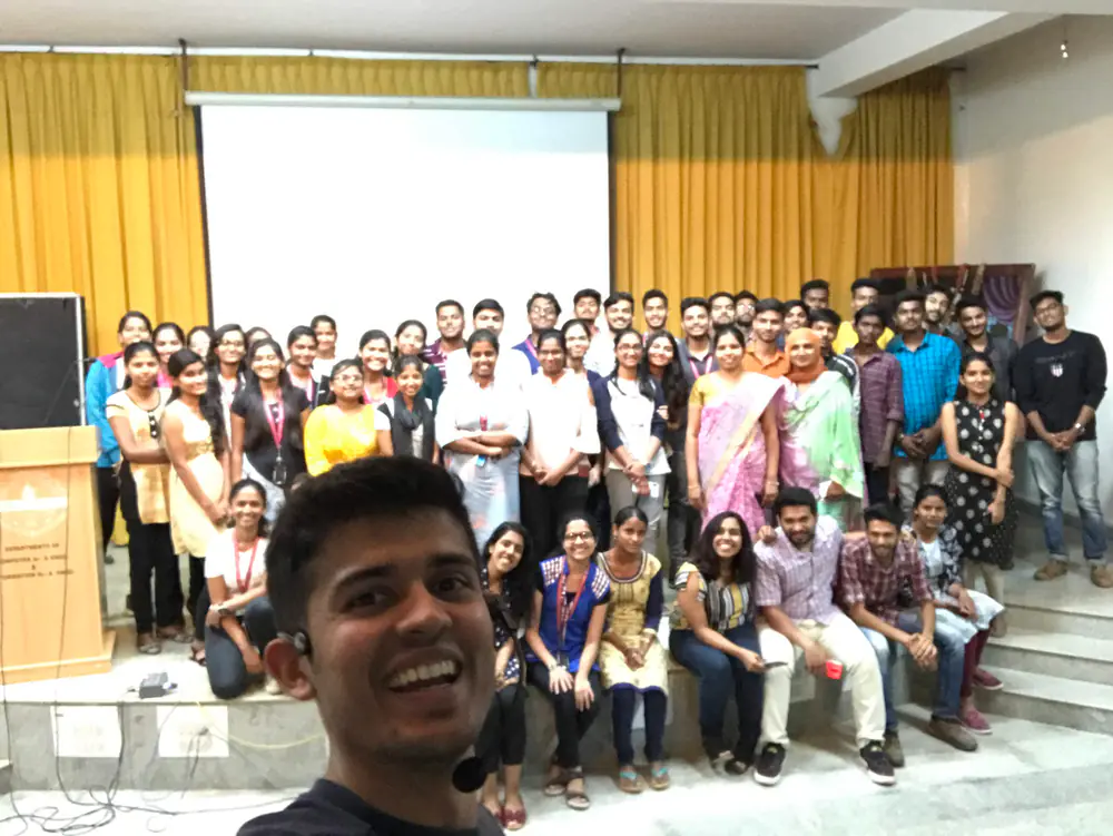 Swastik Nandakumar taking a selfie with a room full of workshop attendees
