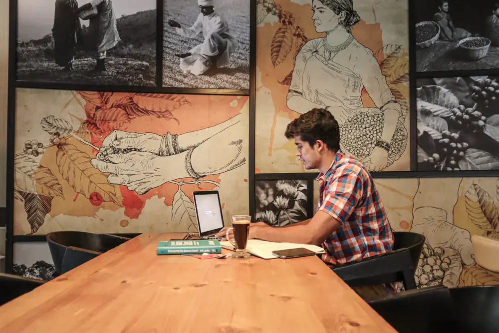Swastik Nandakumar working on his laptop in a cafe