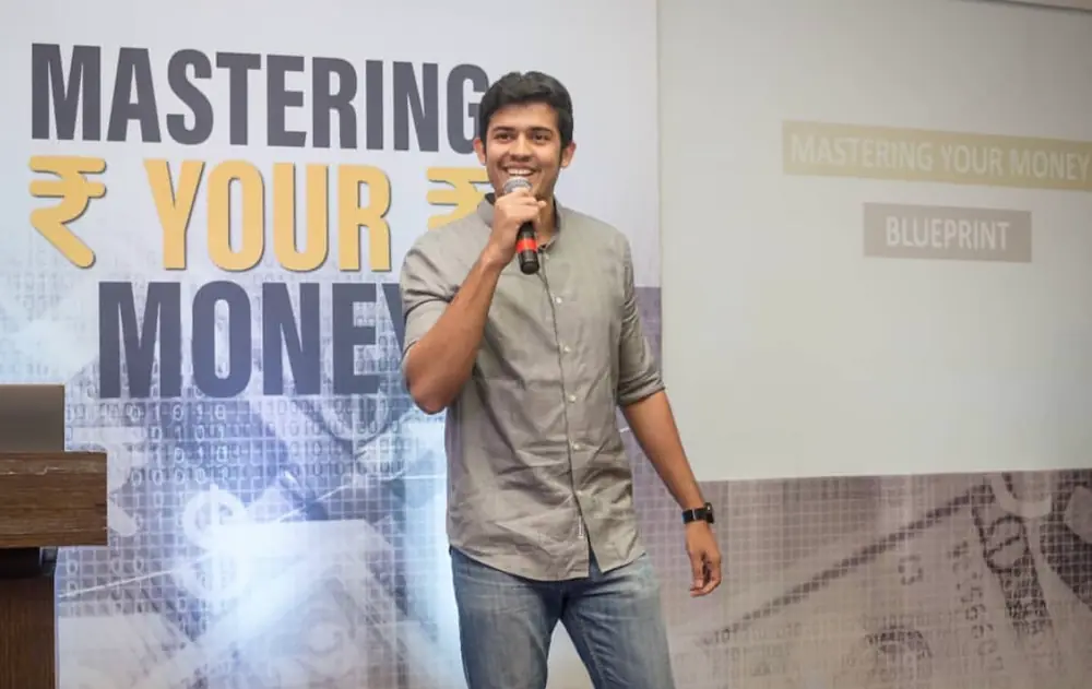 Swastik Nandakumar speaking on stage at Mastering Your Money