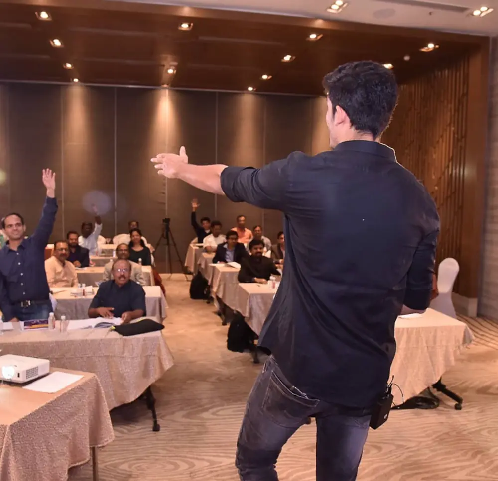 Swastik Nandakumar teaching a hotel conference room of business owners